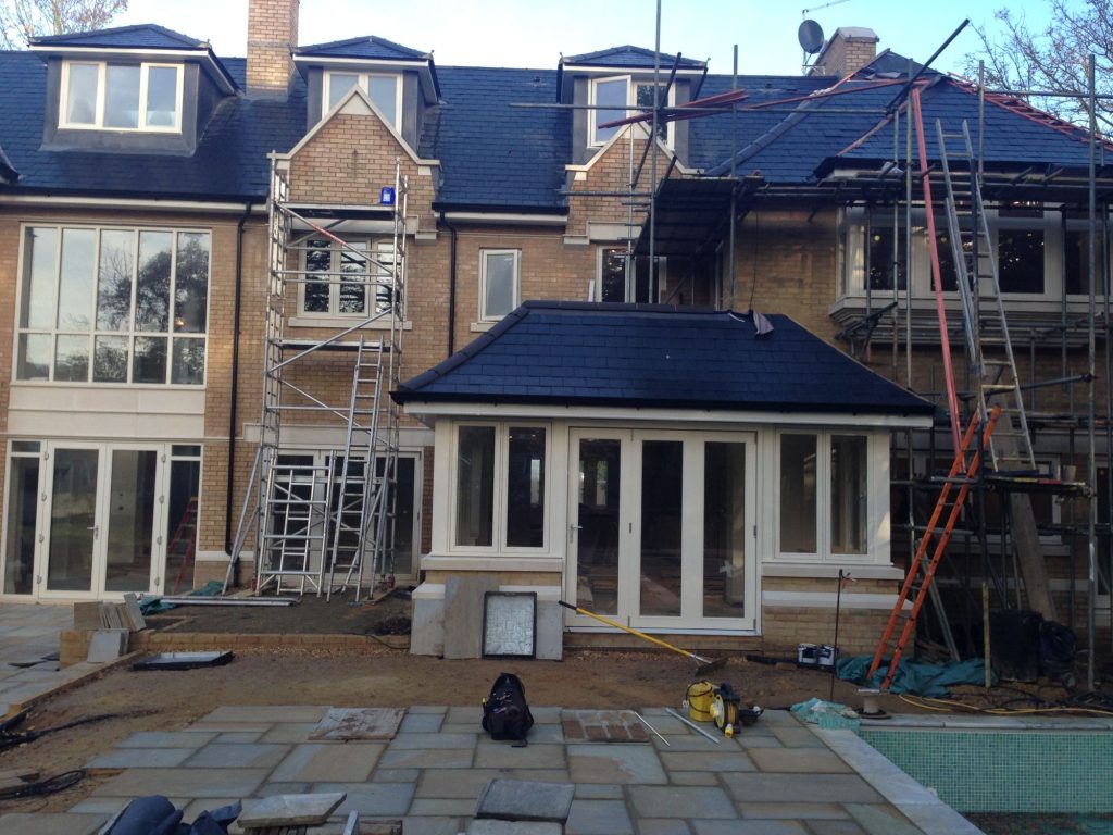 Large house with glass windows and a conservatory